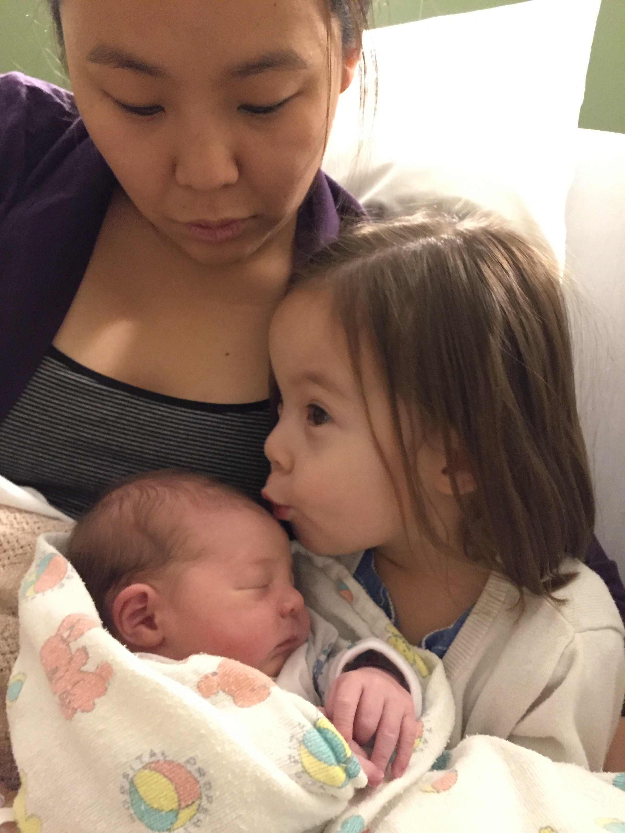 Annie with Lily Grace kissing her new brother, Steven, named after the grandpa she never met.